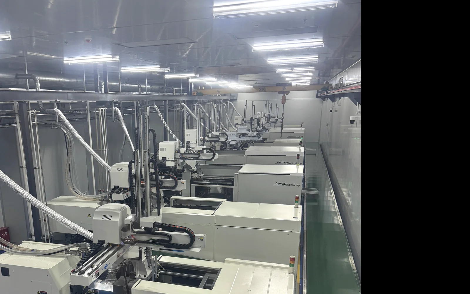 Rows of injection molding machines inside a controlled production environment at a Chinese supplier.
