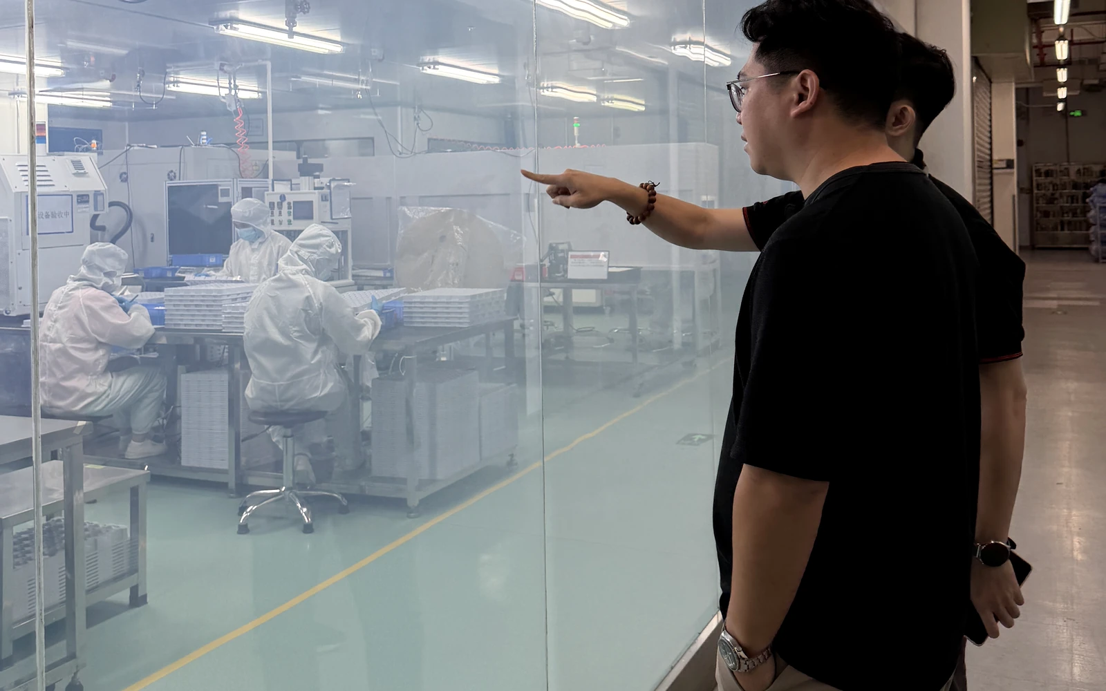 Vorexmed founder reviewing controlled production activities through a cleanroom viewing window at a manufacturing partner site.
